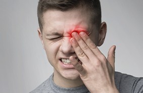 Teen with item stuck in eye holding his face