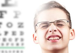 Teen with glasses squinting to see