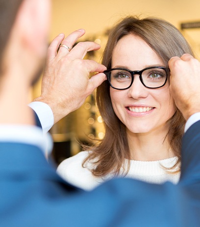 Optometrist helping woman choose the right glasses for her face shape