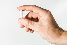 Closeup of patient holding white pill in his hand