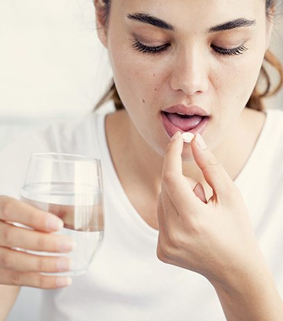 Woman taking oral conscious sedation dentistry pill
