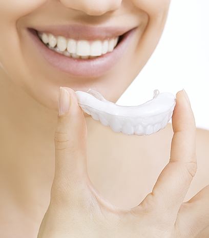 Woman using at home teeth whitening kit
