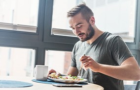 Bearded man eating a meal at a restaurant