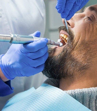  Male dental patient receiving dental checkup and cleaning in Belmont, MA
