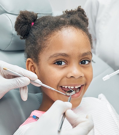Dentist checking child's tooth-colored filling