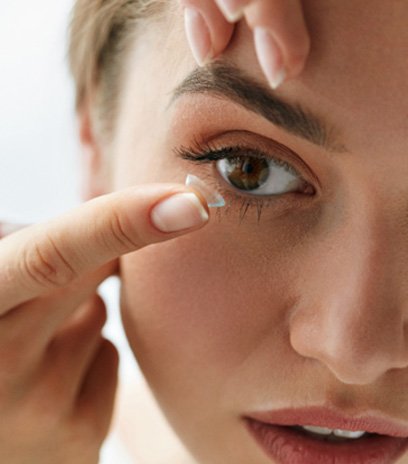 Woman about to place contact lens in Belmont, MA in eye