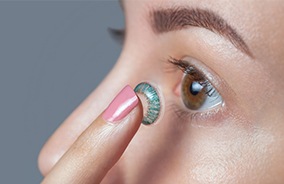 Patient placing colored contact lens