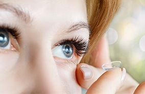 Woman placing a soft contact lens