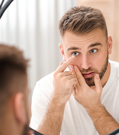 Man placing contact lenses