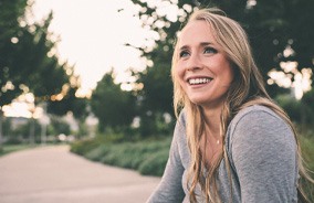 Woman outside smiling after visiting cosmetic dentist in Belmont, MA