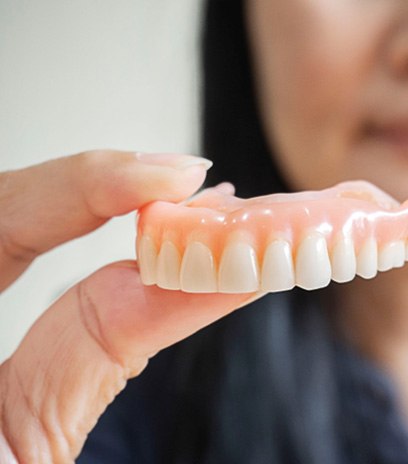 Woman holding dentures