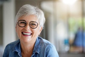 Senior woman with glasses sitting and smiling