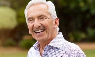 Older man with full smile after replacing missing teeth