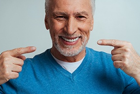 man smiling and pointing at his smile