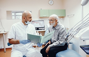 Dentist explaining the cost of dentures in Belmont to patient