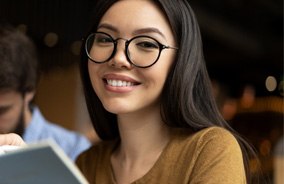 Smiling woman wearing glasses with designer frames in Belmont, MA