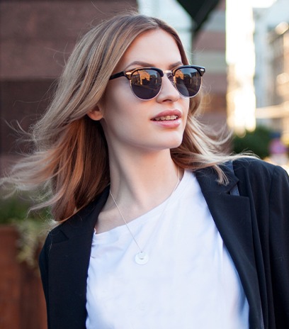 Woman with designer glasses outdoors smiling