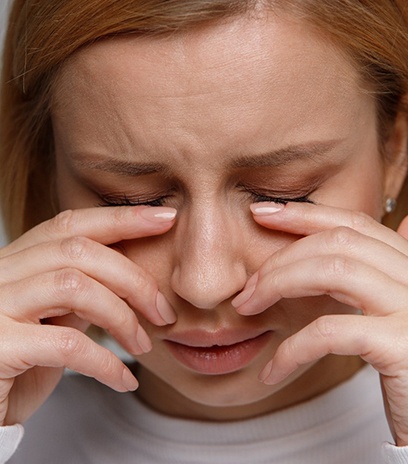 Woman rubbing her face due to dry eye in Belmont, MA