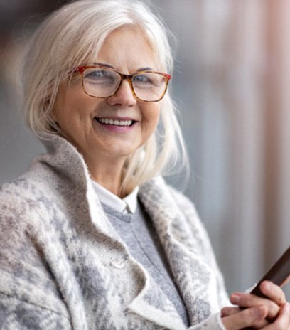 Woman with glasses outside after dry eye treatment