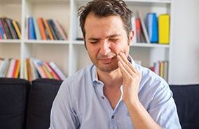 Man holding his cheek due to a toothache