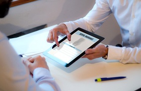 Dentist showing patient dental insurance form on tablet