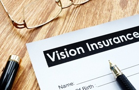 Vision insurance form on wooden table with glasses