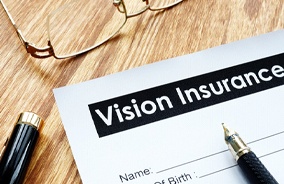 Vision insurance form on wooden table with glasses
