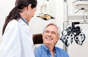 Man smiling at eye doctor after routine eye exam in Belmont, MA