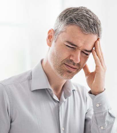 Man seeing floaters and flashes due to ey disease has a headache