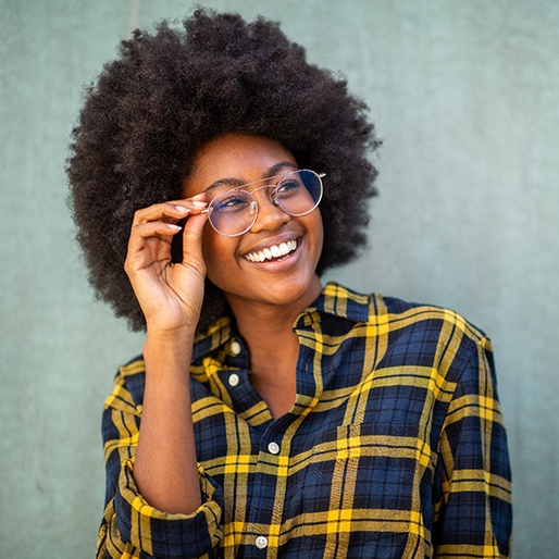 Smiling woman with glasses after visiting an optometrist in Belmont, MA