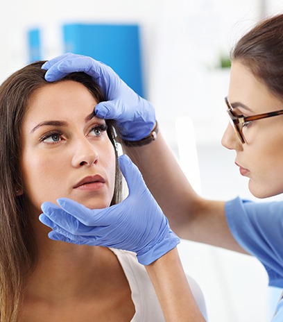 Optometrist examining eyes of woman in pain