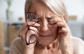 Woman with traumatic eye injury holding face