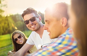 Man smiling wearing transitional lens glasses outdoors