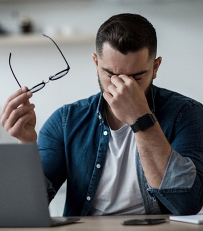 Man rubbing his eyes due to pain