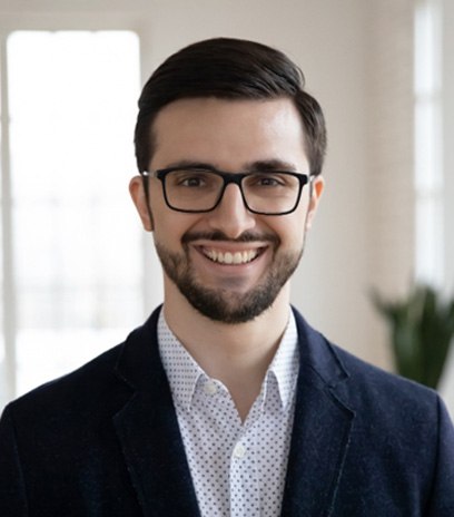 Man with glasses smiling after visiting optometrist in Belmont, MA