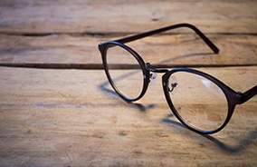 Pair of eyeglasses in Belmont, MA on wooden table