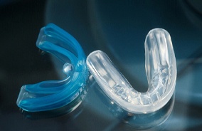 Two mouthguards sitting together on a clear table