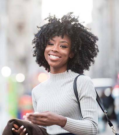 Woman with dental implants in Belmont smiling outside