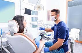 Woman completing dental checkup with an implant dentist in Belmont