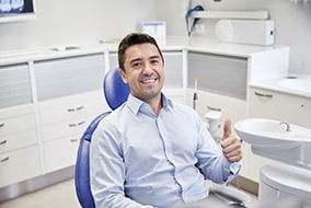 Man giving thumbs up in dental chair