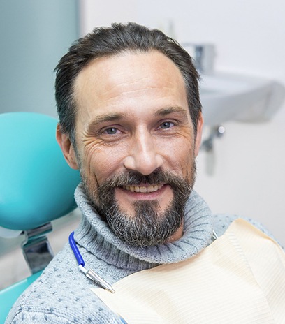 Blonde female patient sitting in dental chair and smiling