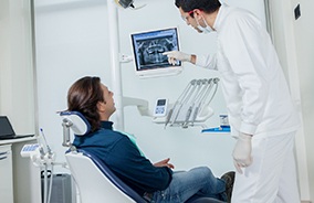 Implant dentist in Belmont showing patient an X-ray.