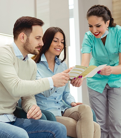 Man and woman looking at dental and vision insurance information in waiting room