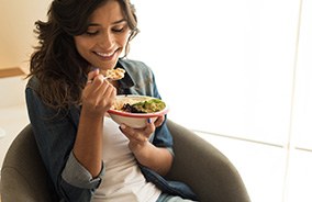 Woman sitting in chair eating a healthy meal