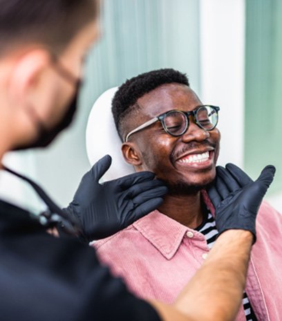 Man wearing glasses and undergoing dental checkup 