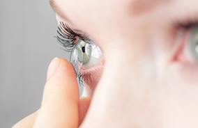 Woman placing contacts for corneal refractive therapy