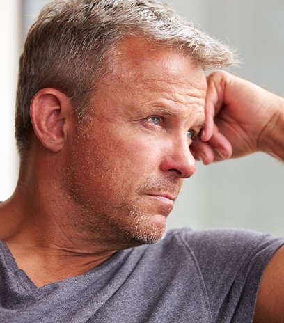 Man with degenerative myopia staring out window