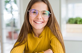 Smiling girl with yellow shirt and glasses