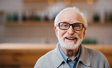 Older man with horn rimmed glasses smiling