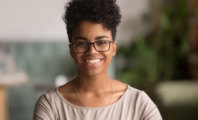 Woman with glasses smiling after myopia treatment